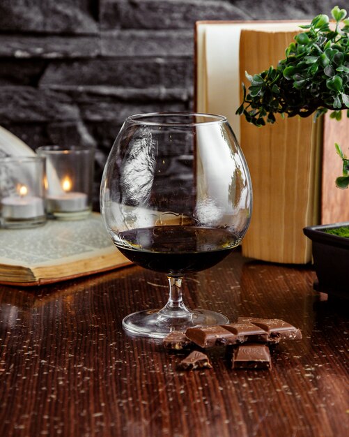 Vista frontale bicchiere di vino rosso con cioccolato