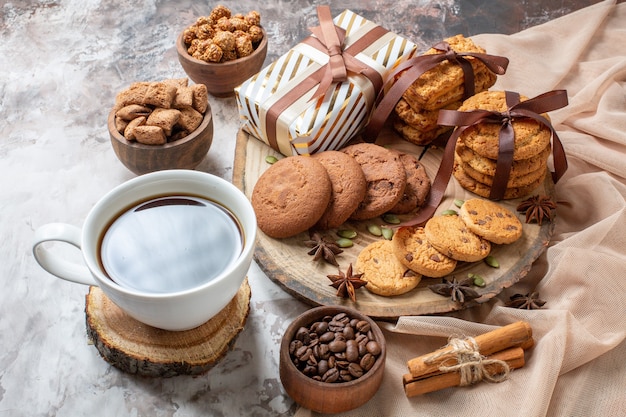 Vista frontale biscotti dolci con noci e regali su sfondo chiaro zucchero tè torta biscotto torta dolce pasticceria