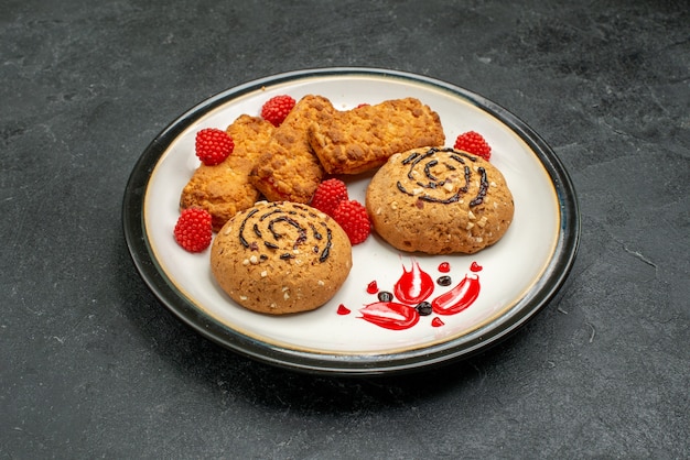 Vista frontale biscotti dolci deliziosi dolci per il tè su uno spazio grigio