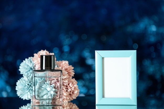 Vista frontale bottiglia di profumo piccola cornice blu fiori su sfondo blu scuro