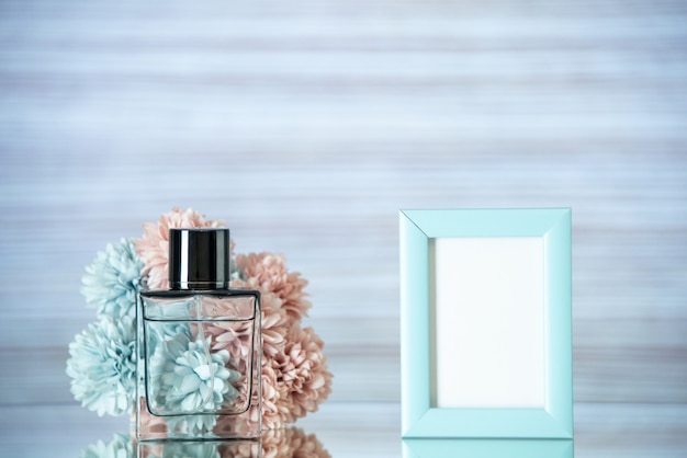 Vista frontale bottiglia di profumo piccoli fiori blu cornice per foto