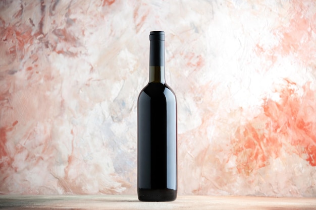 Vista frontale bottiglia di vino su uno sfondo chiaro alcol uva drink bar foto vacanza cena succo di limonata