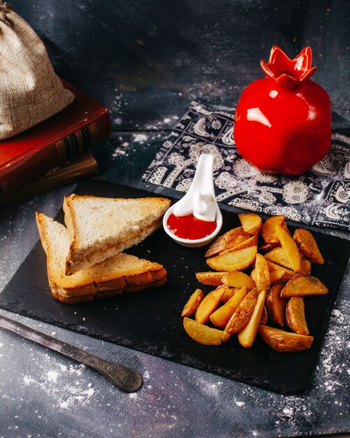 Vista frontale brindisi con patate fritte e ketchup con maionese sulla superficie grigia