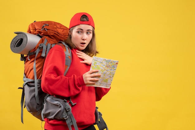 Vista frontale chiedeva escursionista femminile con zaino rosso che tiene mappa
