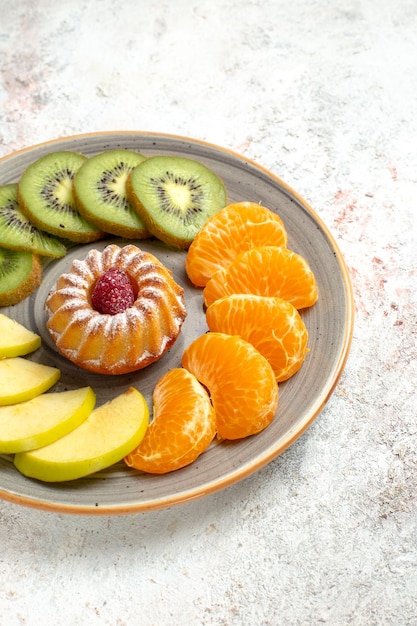 Vista frontale composizione di frutta diversa frutta fresca e affettata con poca torta su sfondo bianco frutti maturi dolci salute