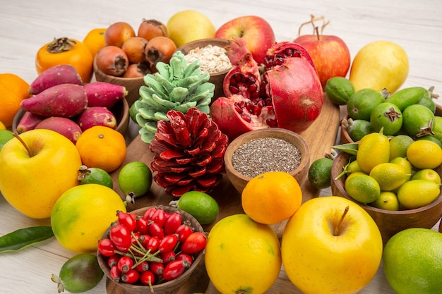 Vista frontale composizione di frutta fresca frutti diversi su sfondo bianco gustosa salute agrume colore bacca dieta esotica