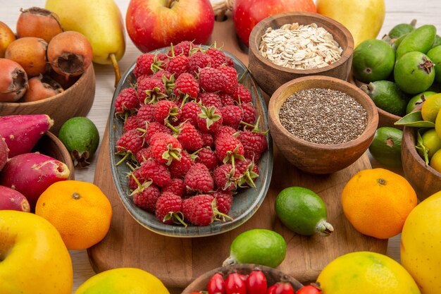 Vista frontale composizione di frutta fresca frutti diversi su sfondo bianco salute agrume colore bacca matura gustosa dieta esotica