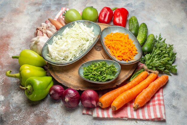 Vista frontale composizione di verdure fresche affettate e verdure intere su sfondo bianco colore maturo vita sana dieta insalata