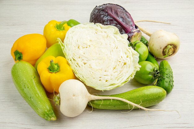 Vista frontale composizione vegetale cavolo peperoni e ravanelli su sfondo bianco pasto colore insalata matura foto maturi molti