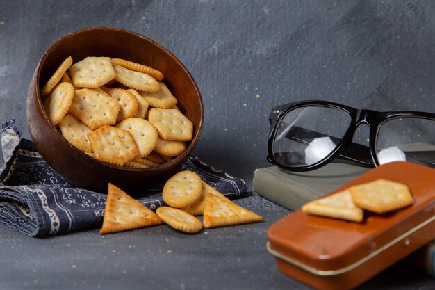 Vista frontale cracker salati con occhiali da sole su grigio