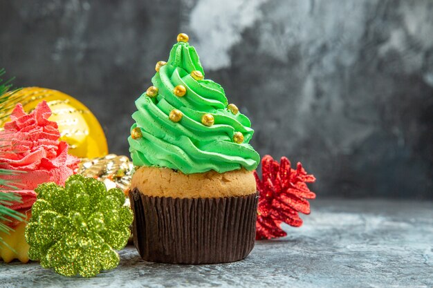Vista frontale cupcakes colorati ornamenti di natale su sfondo grigio isolato