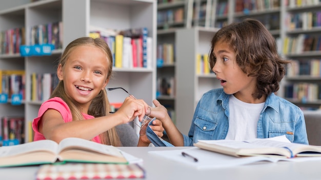 Vista frontale dei bambini che giocano in biblioteca