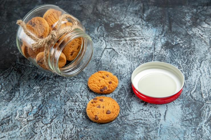 Foto gratuito vista frontale dei biscotti dolci all'interno della latta di vetro sulla superficie scura