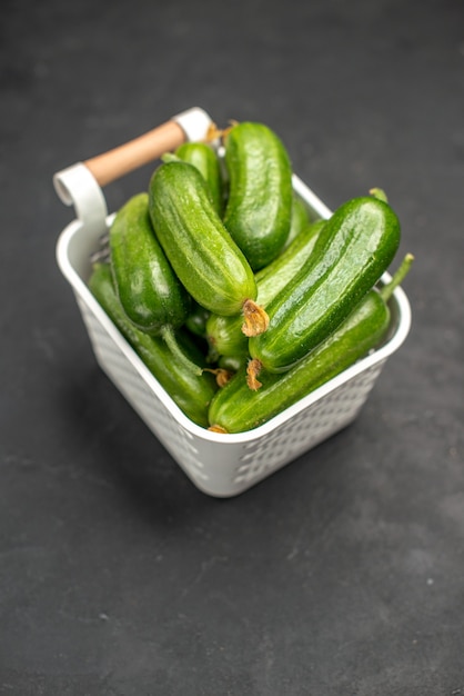 Vista frontale dei cetrioli verdi freschi all'interno del cesto su uno sfondo scuro insalata cibo salute foto a colori