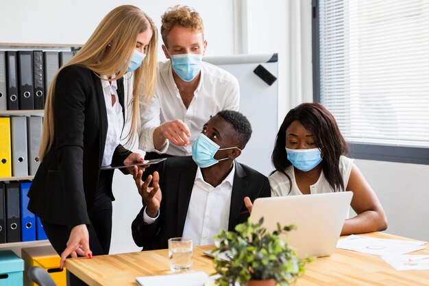 Vista frontale dei colleghi che lavorano durante il covid