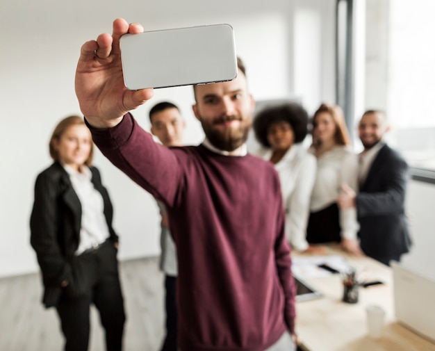 Vista frontale dei colleghi che prendono un selfie