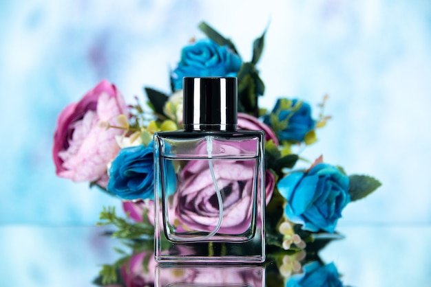 Vista frontale dei fiori colorati della bottiglia di profumo rettangolari su azzurro