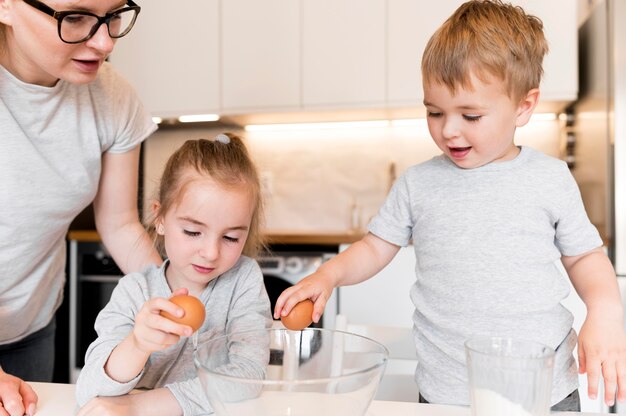 Vista frontale dei fratelli che cucinano a casa