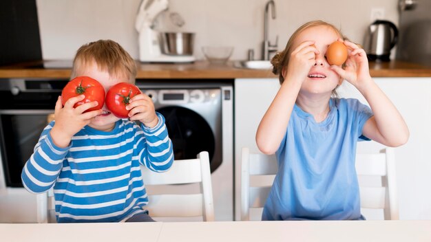 Vista frontale dei fratelli che cucinano a casa