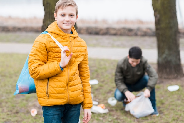 Vista frontale dei ragazzi con il sacchetto di plastica