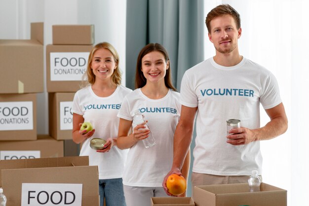 Vista frontale dei volontari in posa mentre aiutano con le donazioni di cibo