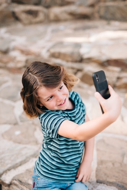 Vista frontale del bambino che prende un selfie