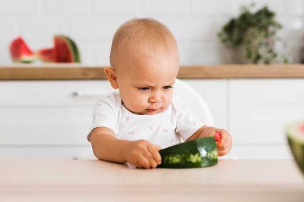 Vista frontale del bel bambino che mangia anguria