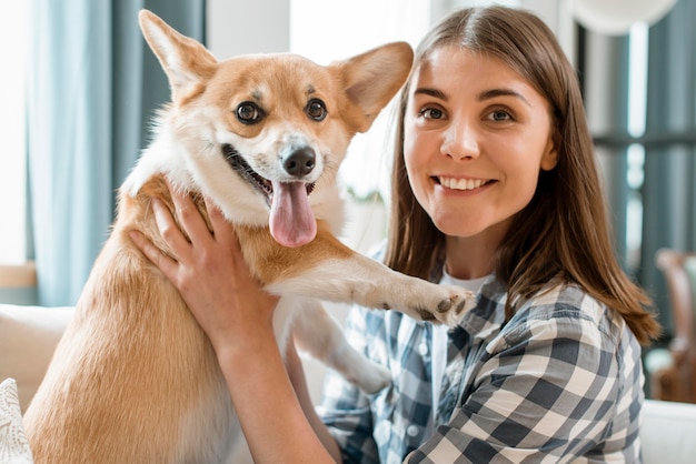 Vista frontale del cane e della donna che posano insieme