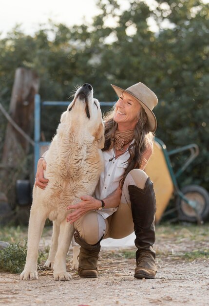 Vista frontale del contadino femminile di smiley con il suo cane da fattoria
