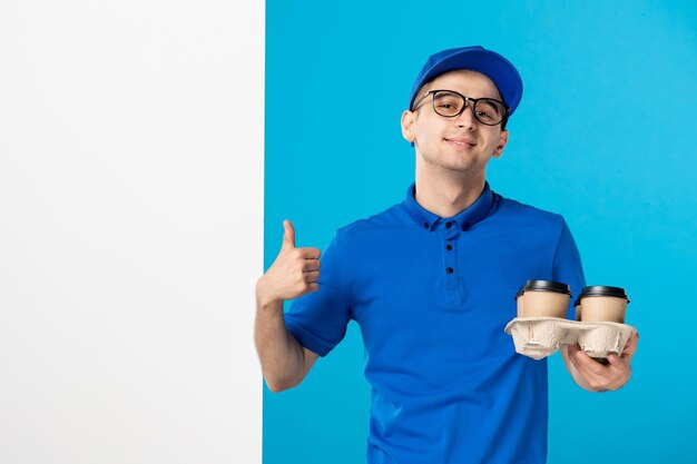 Vista frontale del corriere maschio con consegna caffè sull'azzurro