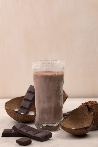 Vista frontale del frappè al cioccolato in vetro con cocco e copia spazio