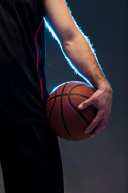 Vista frontale del giocatore di basket con la palla in mano