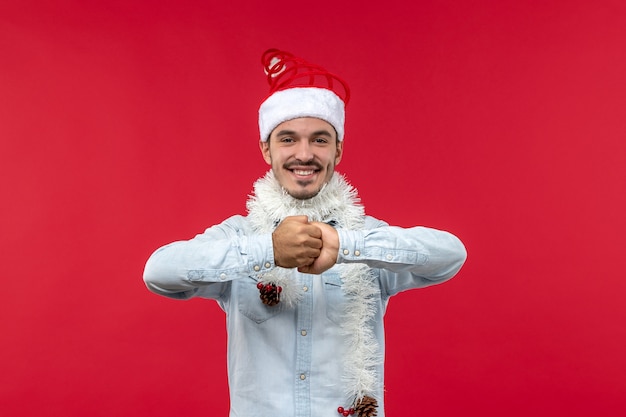 Vista frontale del giovane con espressione sorridente sulla parete rossa