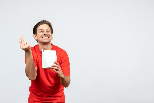 Vista frontale del giovane ragazzo felice in camicetta rossa che tiene la scatola di carta su priorità bassa bianca