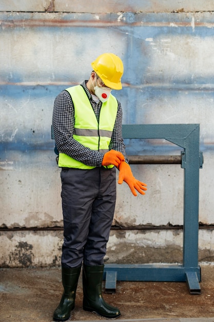 Vista frontale del lavoratore con giubbotto riflettente e elmetto