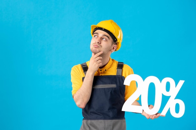 Vista frontale del lavoratore maschio di pensiero in uniforme con la scrittura sull'azzurro