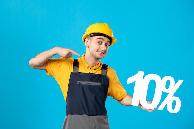 Vista frontale del lavoratore maschio sorridente in uniforme con la scrittura sull'azzurro