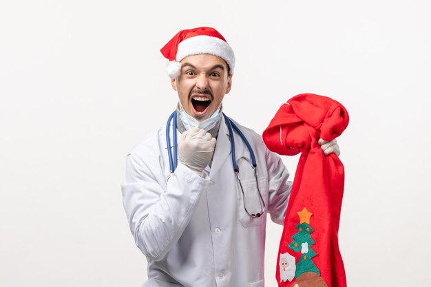 Vista frontale del medico maschio che grida sul muro bianco