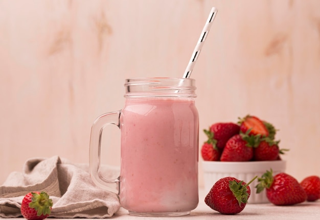 Vista frontale del milkshake alla fragola con paglia