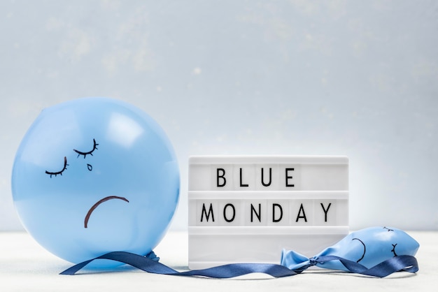 Vista frontale del palloncino triste con scatola luminosa per lunedì blu