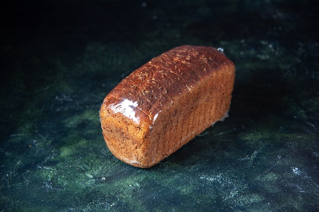Vista frontale del pane nero confezionato su sfondo di colori misti blu e nero con spazio libero