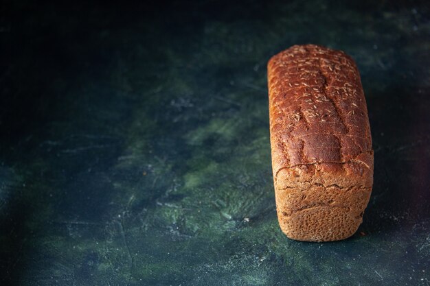 Vista frontale del pane nero confezionato sul lato sinistro su sfondo blu in difficoltà con spazio libero