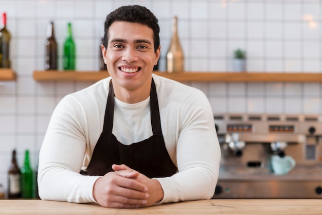 Vista frontale del ragazzo barista nella caffetteria