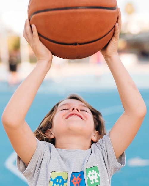 Vista frontale del ragazzo che gioca a basket