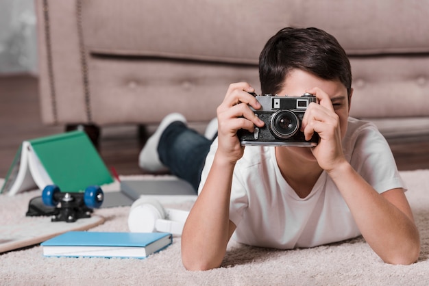 Vista frontale del ragazzo che tiene una macchina fotografica