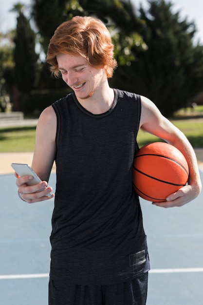 Vista frontale del ragazzo con la palla da basket