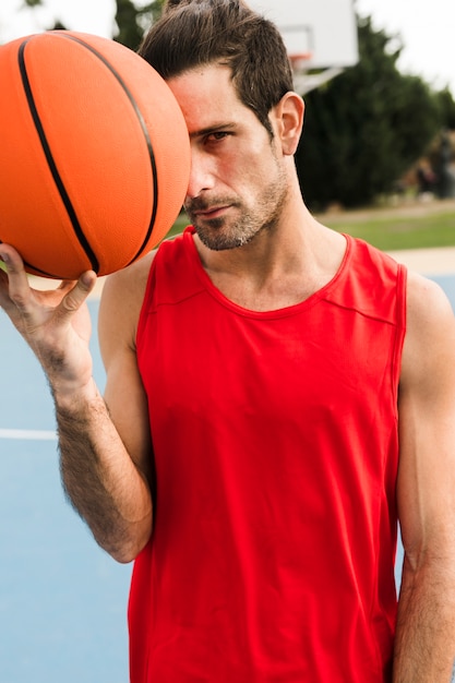 Vista frontale del ragazzo con la palla da basket