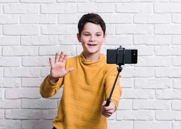 Vista frontale del ragazzo moderno che prende un selfie