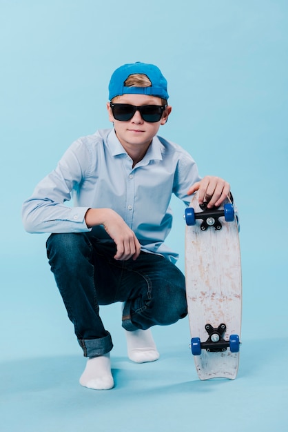 Vista frontale del ragazzo moderno con skateboard