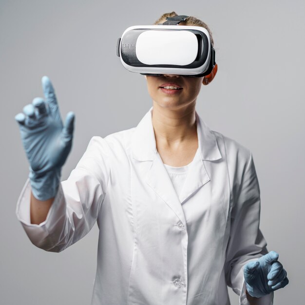 Vista frontale del ricercatore femminile utilizzando un auricolare per realtà virtuale